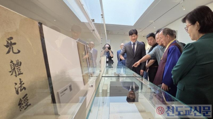 개막식 후 마련된 전시 해설을 들으며 유물들을 관람하고 있는 박인준 교령(사진 오른쪽에서 두 번째)과 최인경 사회문화관장(사진 오른쪽에서 세 번째). 사진 왼쪽 끝으로 의암 손병희 성사가 지은 무체법경(無體法經) 표지 패널이 보인다. 사진 맨 오른쪽은 이순희 강북구청장.jpg